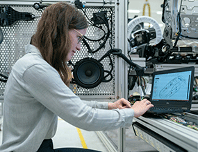 An engineering student working at her laptop in a laboratory setting.